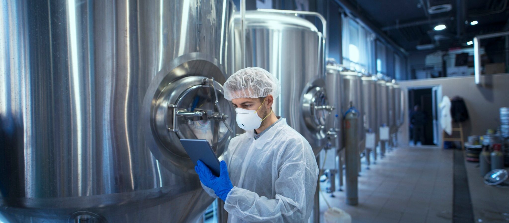 factory-worker-technologist-protective-uniform-with-hairnet-mask-controlling-food-production-tablet-computer_342744-252